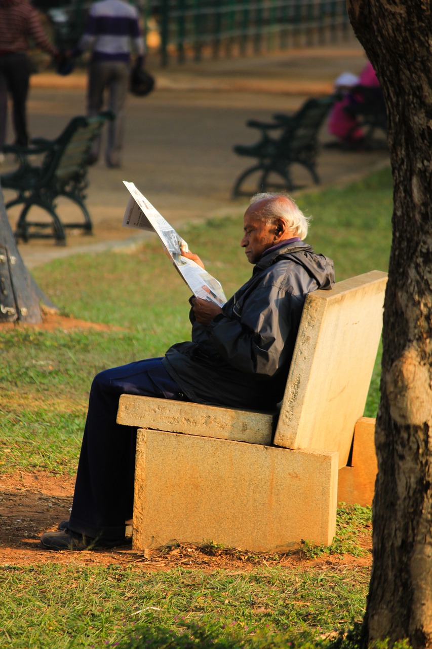 aged person reading park bench free photo