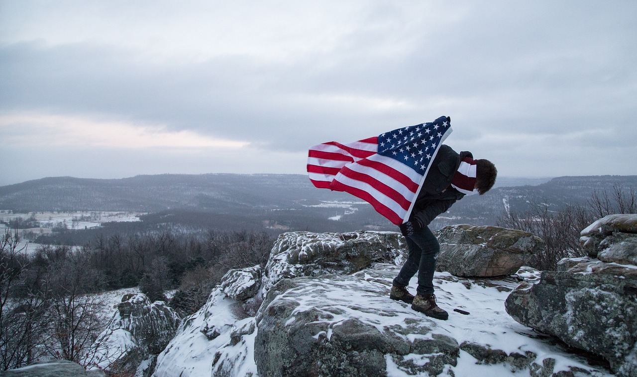 american flag holding mountain top free photo