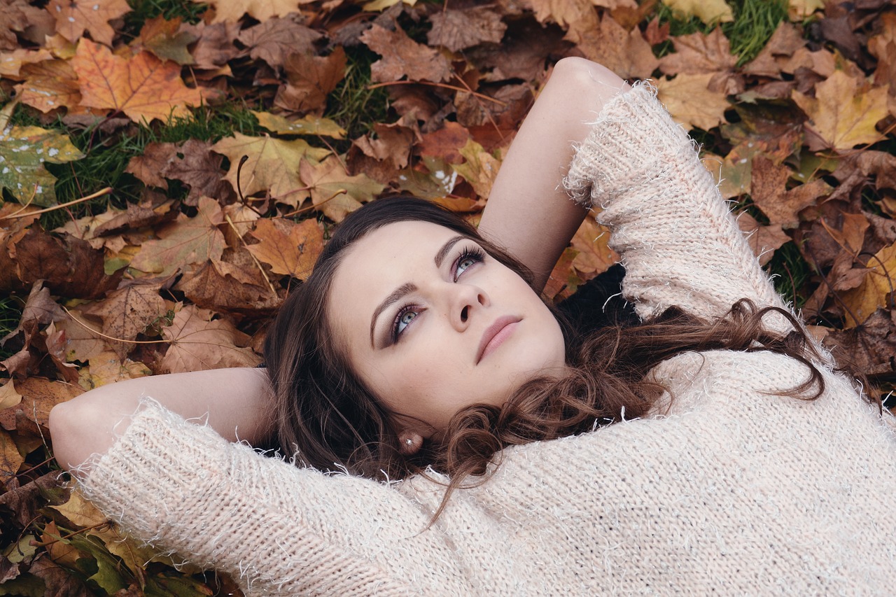 beautiful girl in the park lying on the leaves free photo