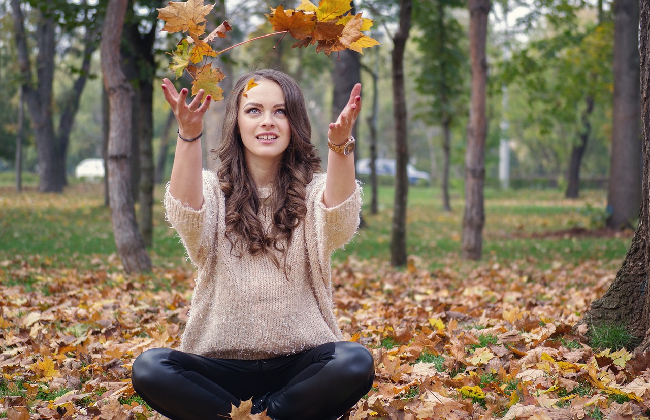 beautiful girl in the park throwing leaves free photo