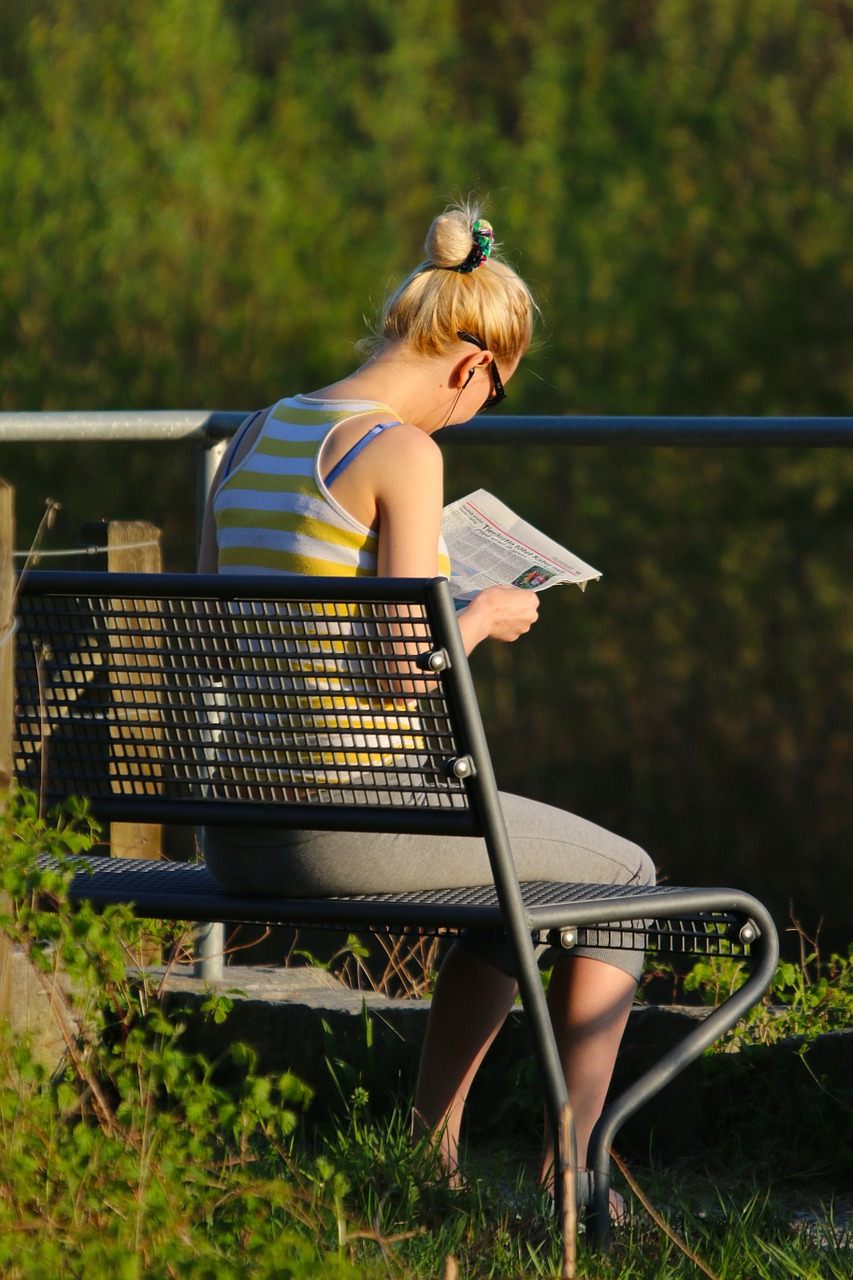 bench woman reading a newspaper free photo