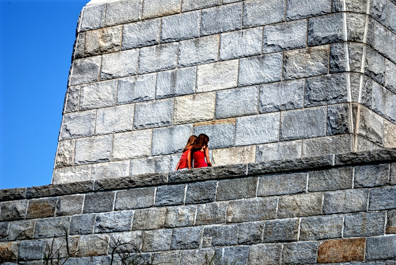 best friends whispering stone wall free photo
