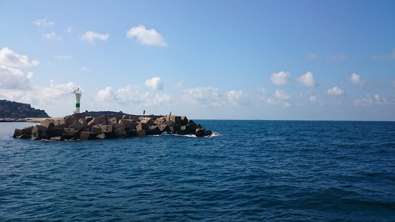 blue sea  stones  lighthouse free photo