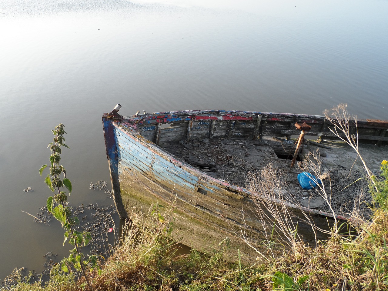 boat in calm water old boat in need of paint wreck of a boat free photo