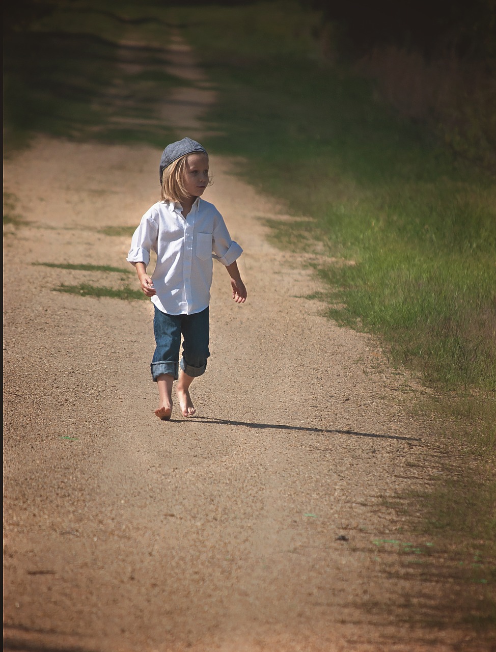 boy walking dirt road free photo