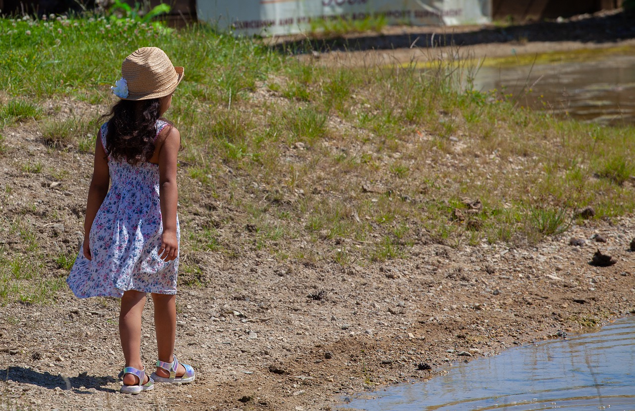 child on pond shore  child in hat  child free photo