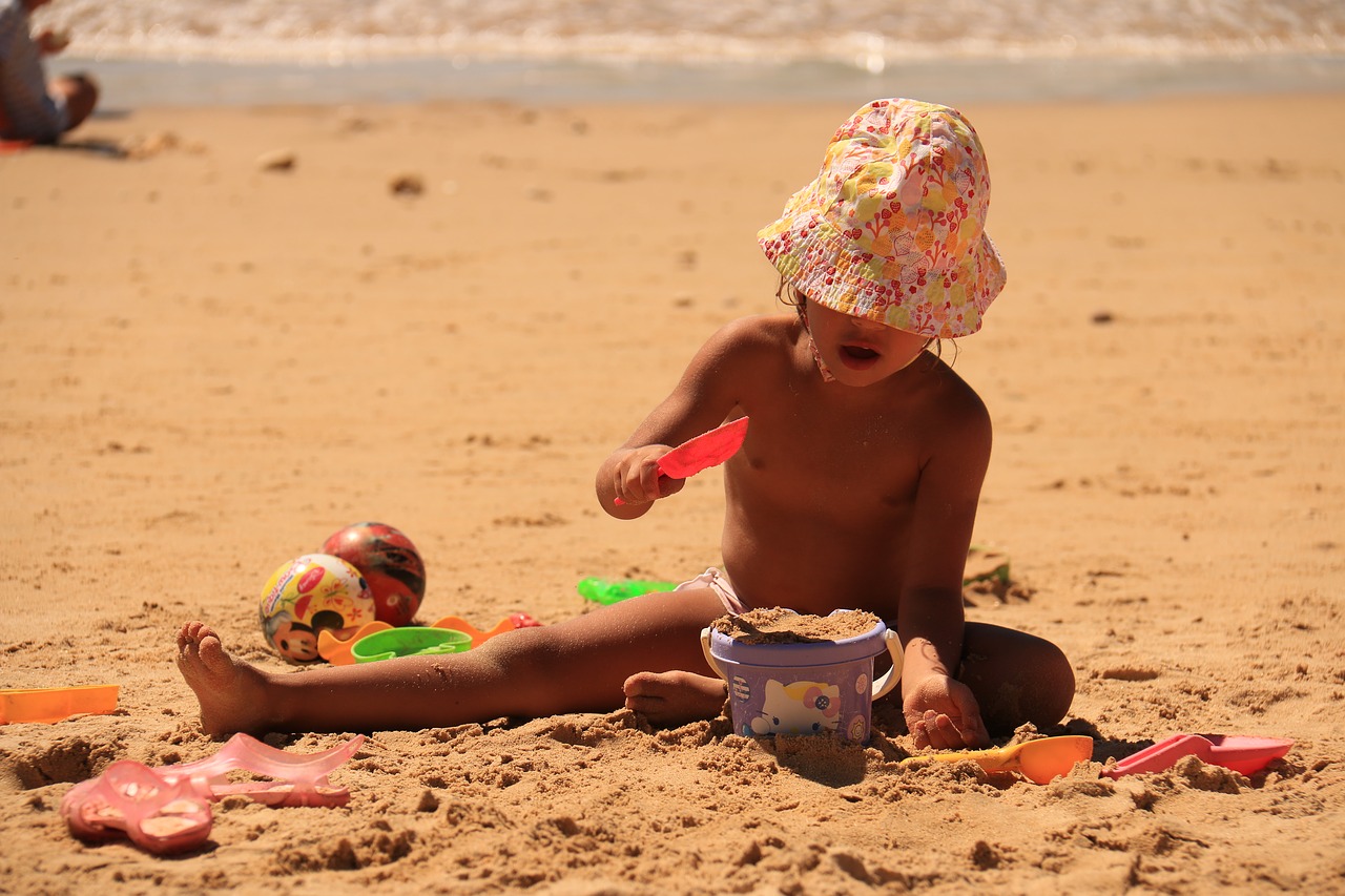 child playing sand beach free photo