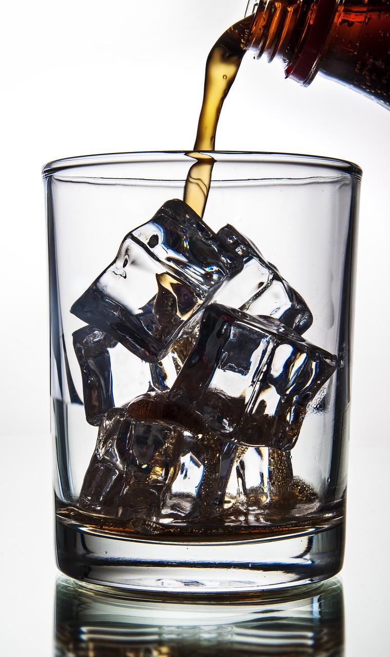 cola pouring in a glass with ice ice glass free photo