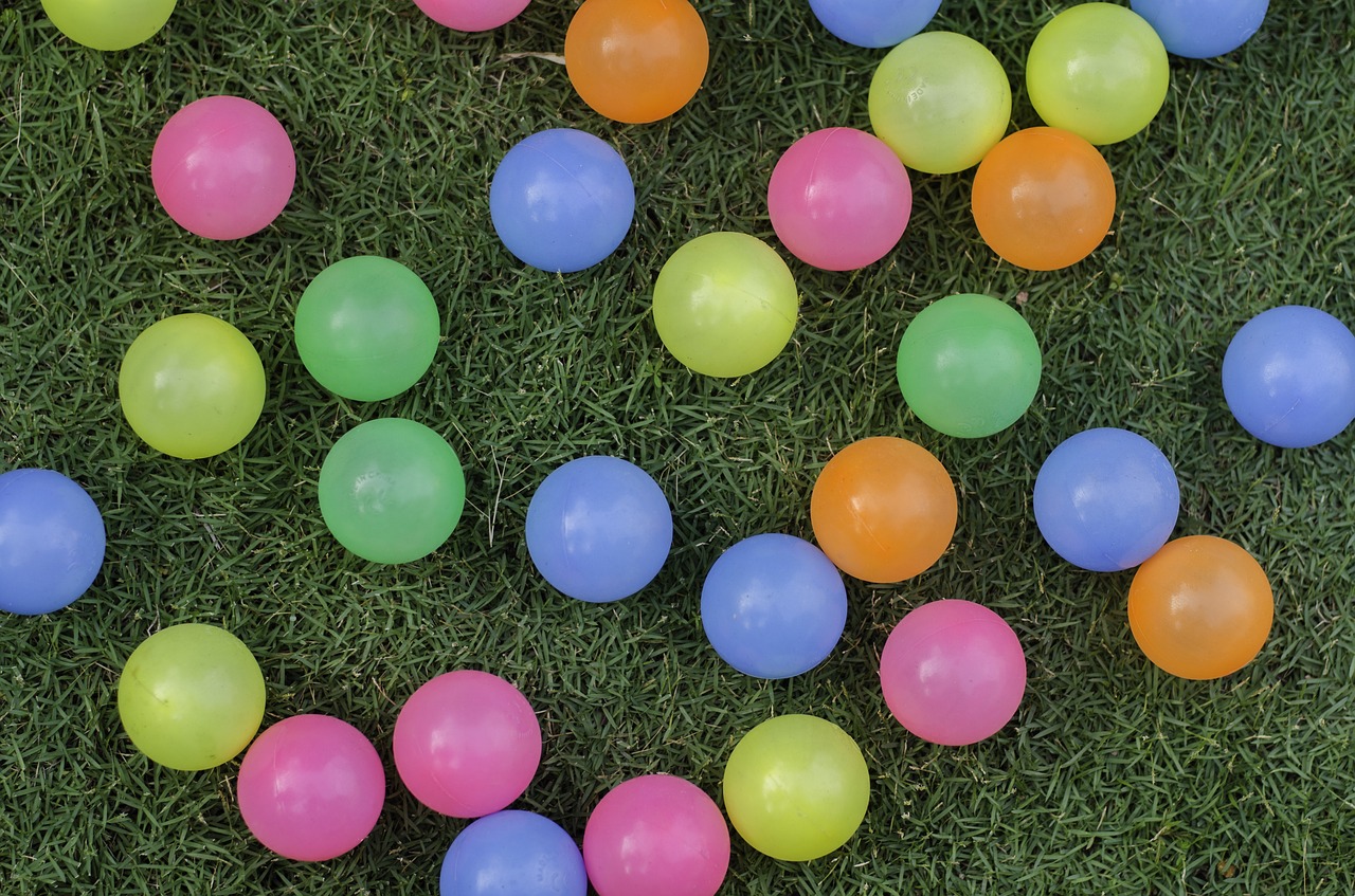 colorful balls on grass field balls grass free photo