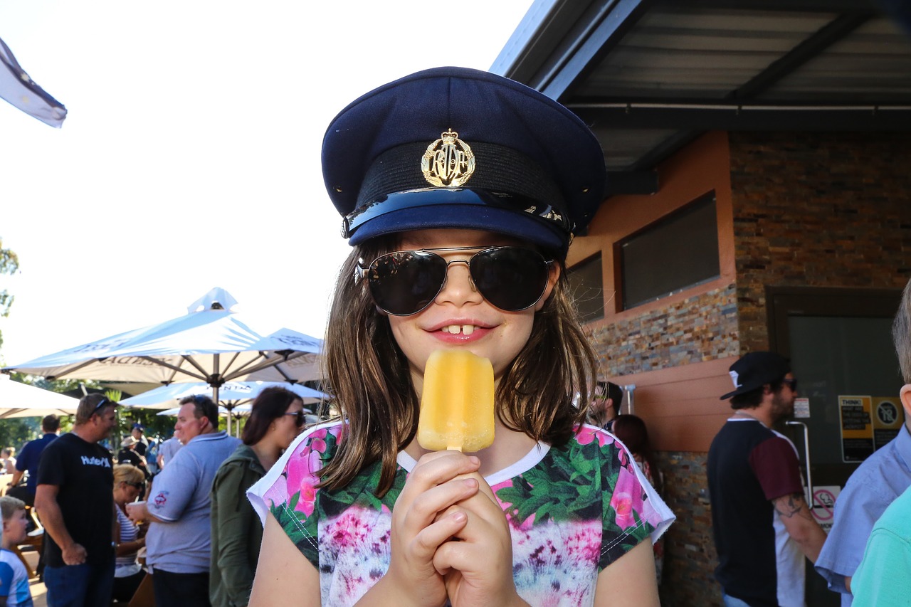 cute girl eating iced lolly free photo