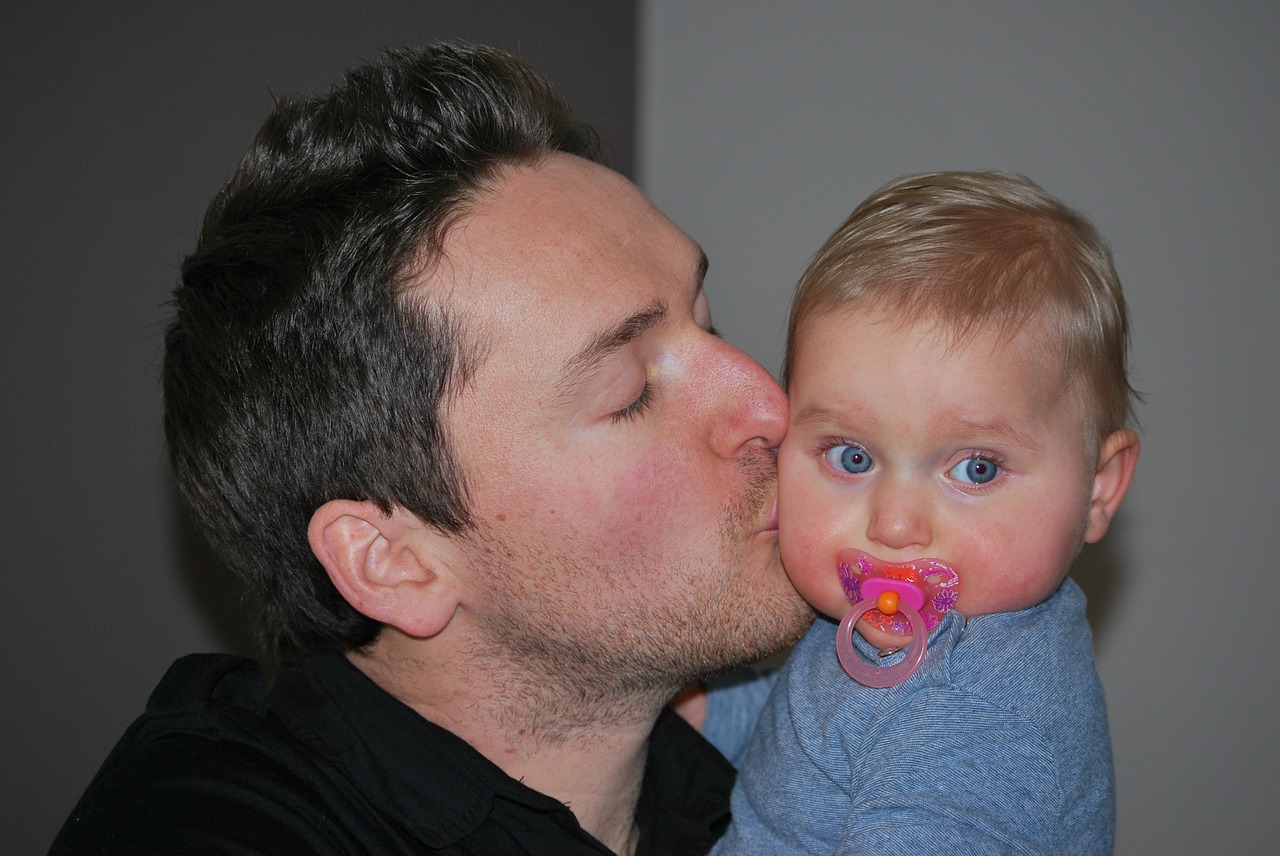 father with child baby kiss free photo