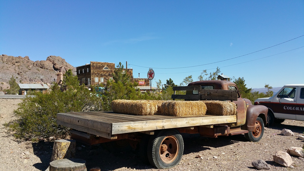 flatbed truck with rust old town background old truck in foreground free photo