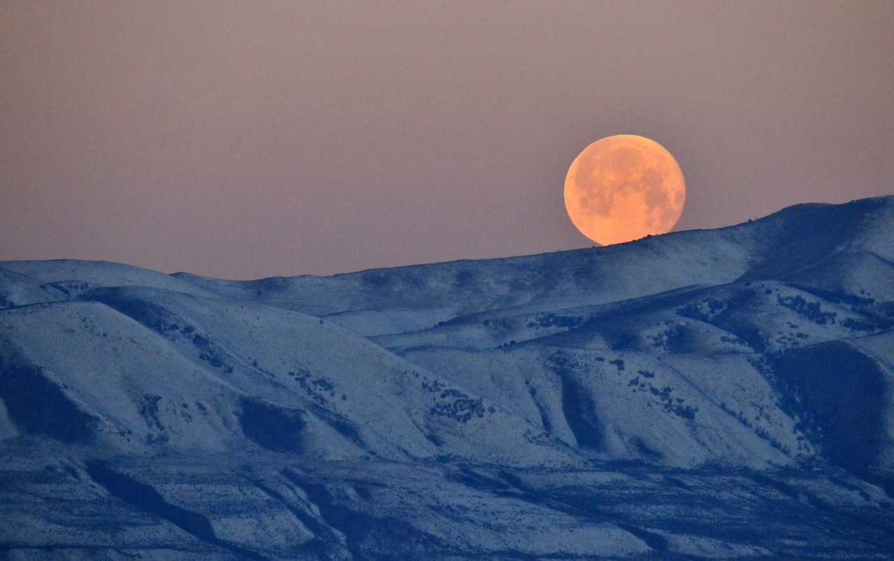 full moon setting mountains free photo