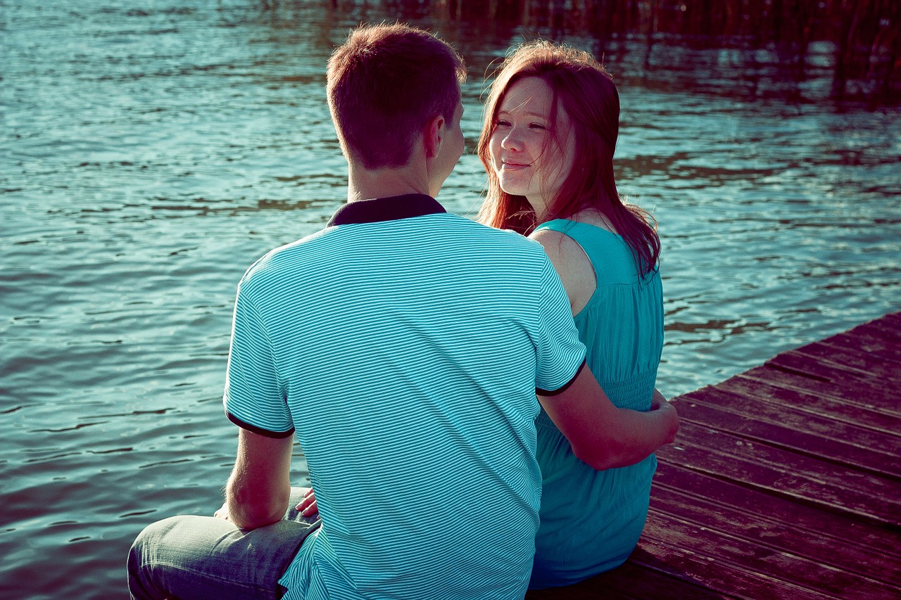 girl and guy on the shore of the pond by the water free photo