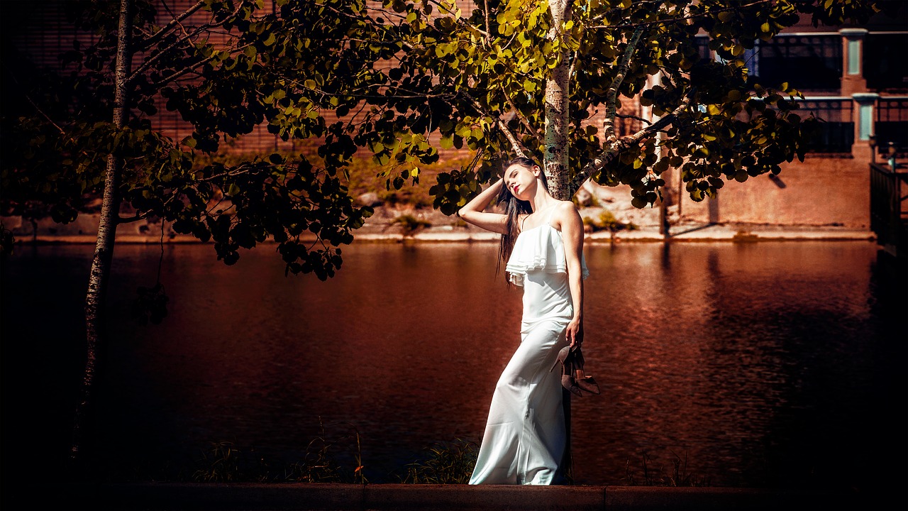 girl in white dress keeps shoes hands free photo