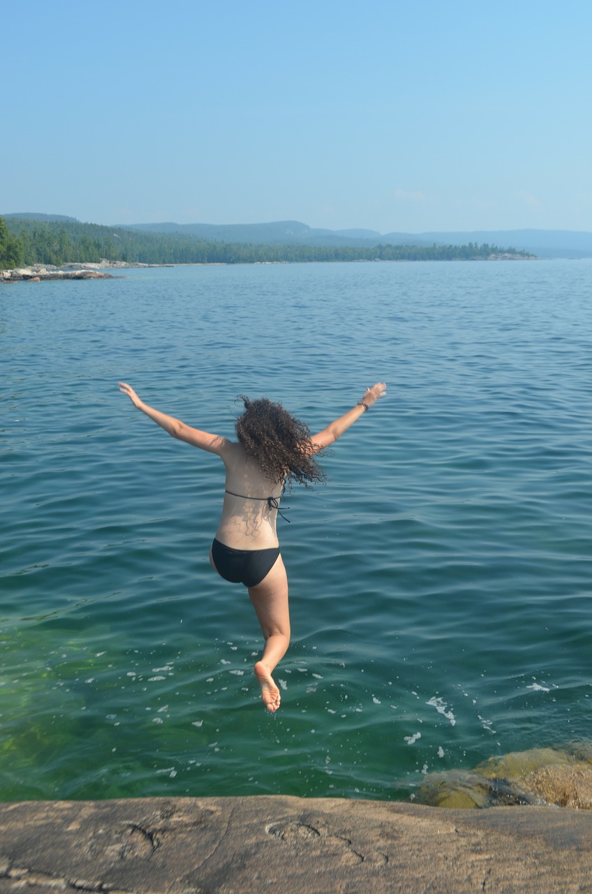 girl jumping into water swimming rock jump free photo