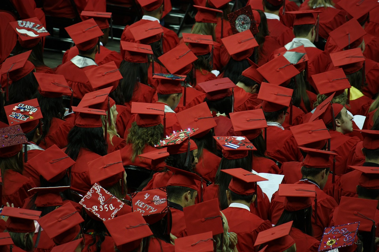 graduates graduation cap and gown free photo
