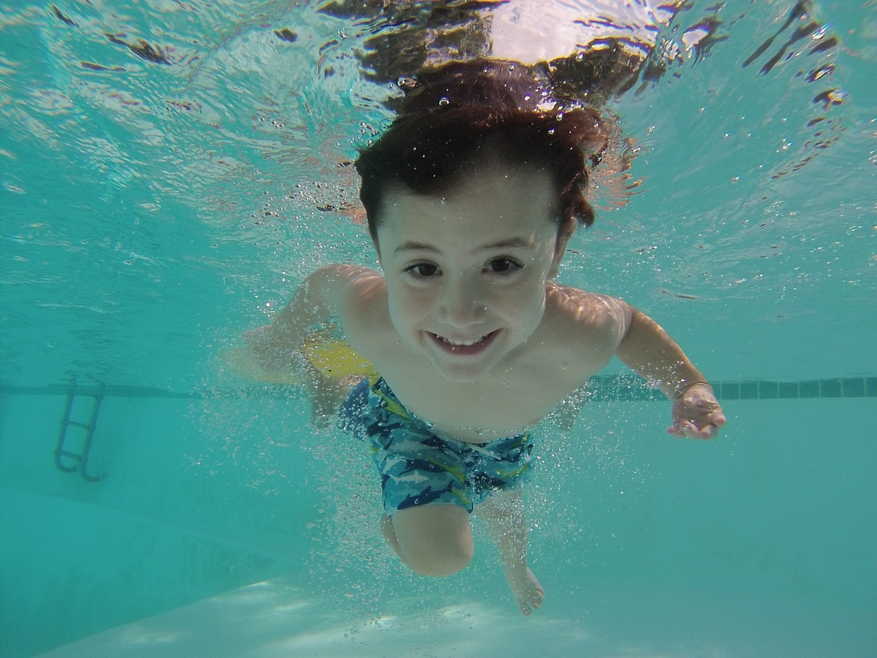 kid swimming underwater free photo