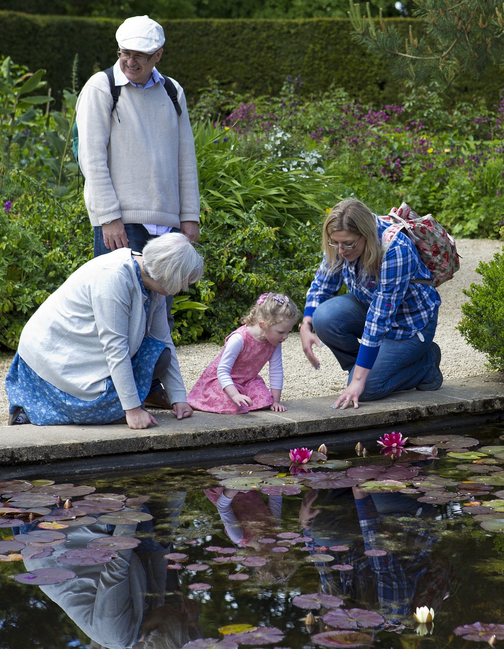 lilly pond little girl in pink dress mother and grandparents free photo
