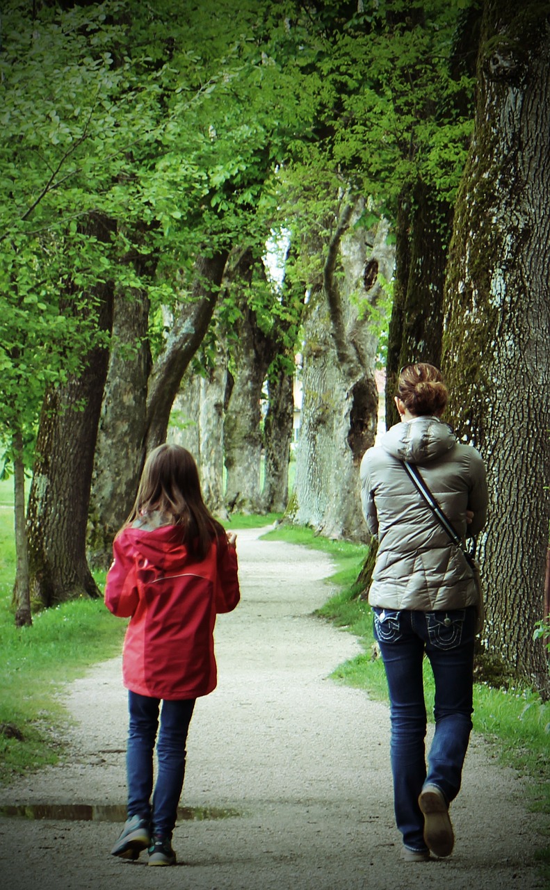 Mother And Daughter Walking In The Park Stock Photo - Download