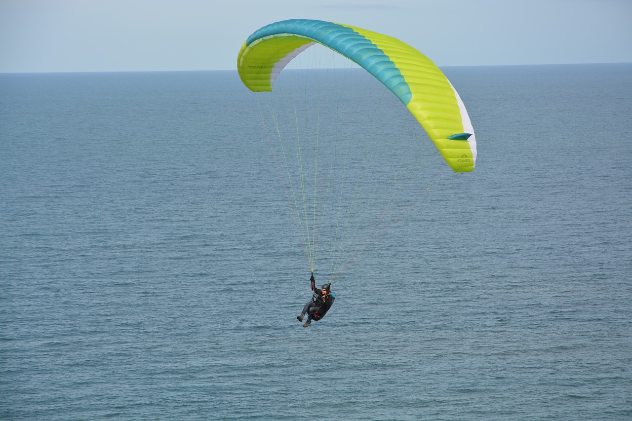 paragliding flight over sea paraglider veil yellow green free photo