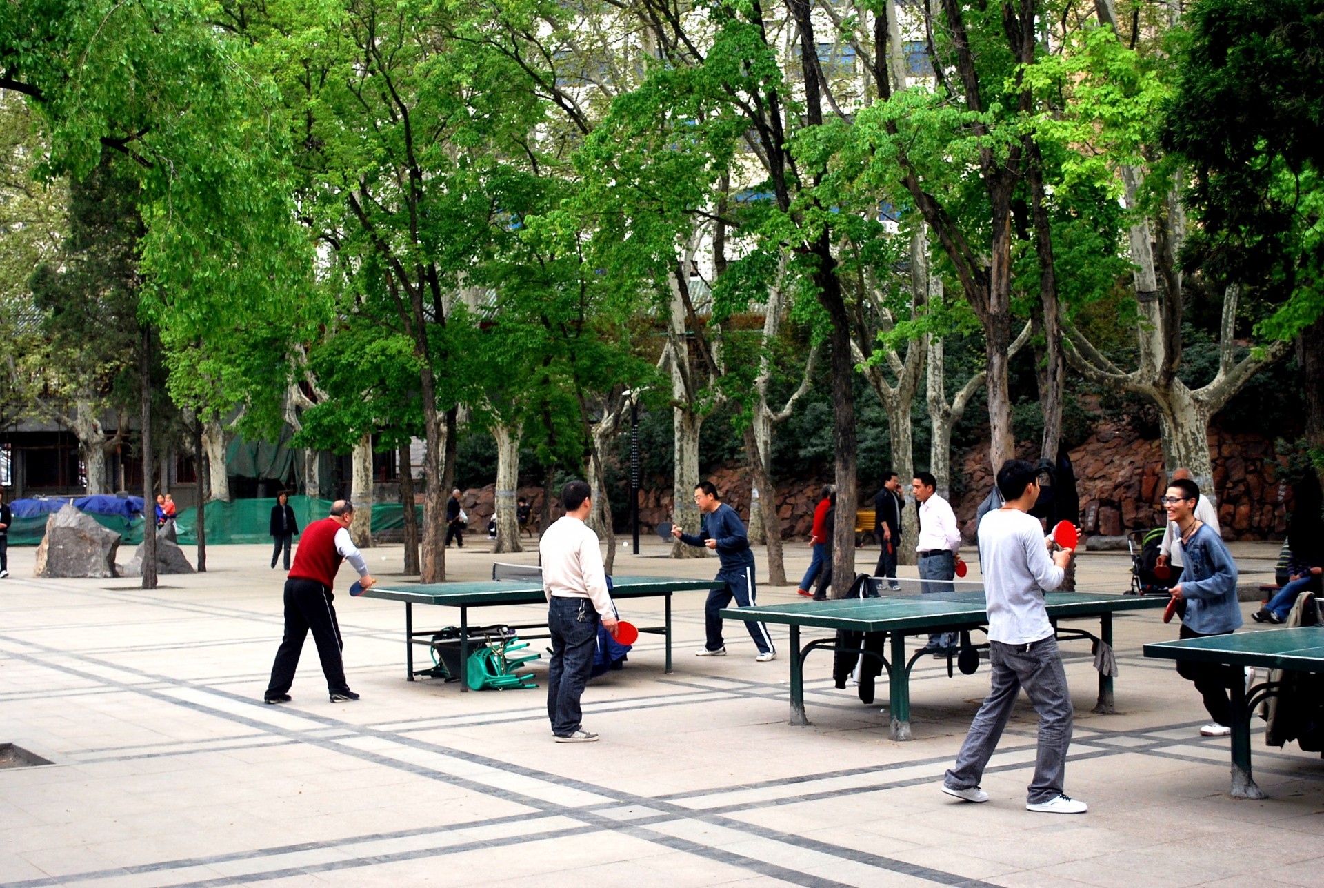 Люди играют в настольный теннис в парке
