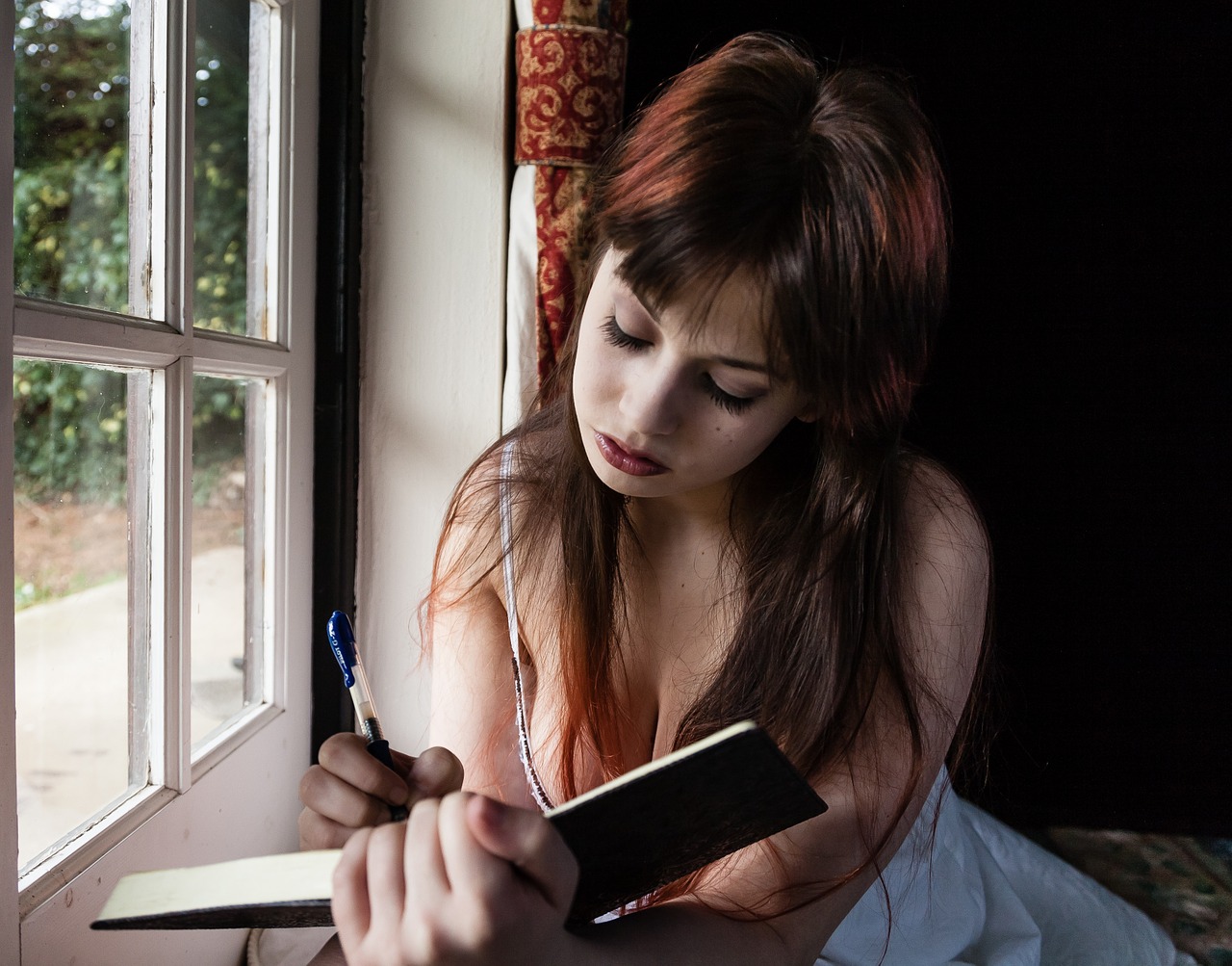 sad woman writing diary free photo
