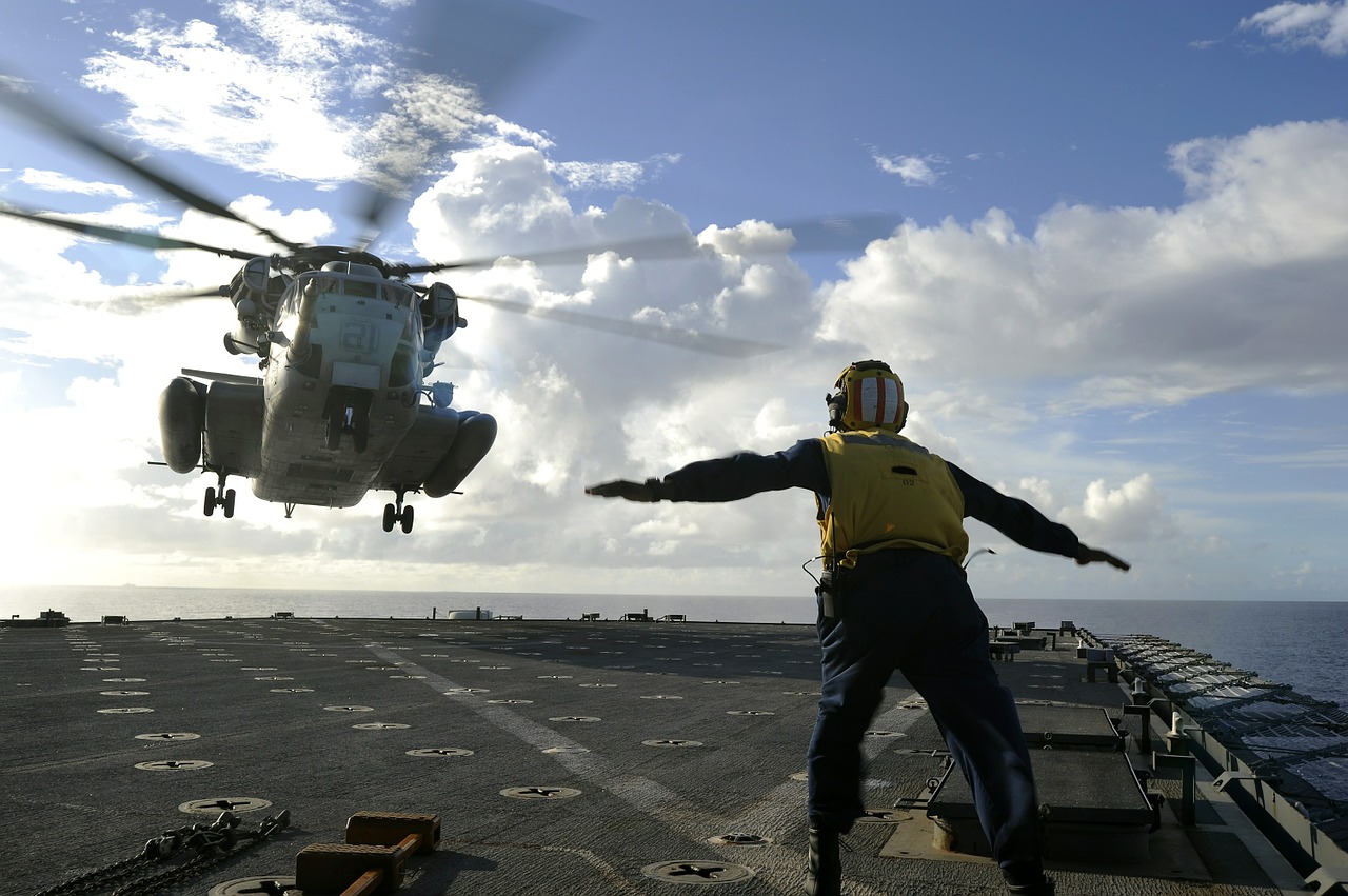 sailor directing helicopter landing ship free photo