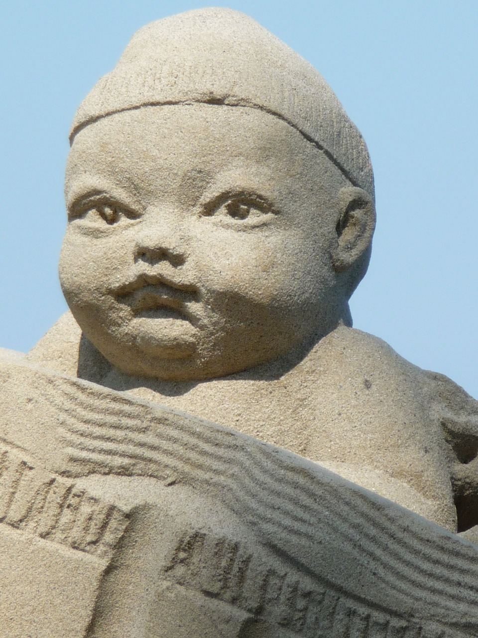 sand sculpture baby face free photo