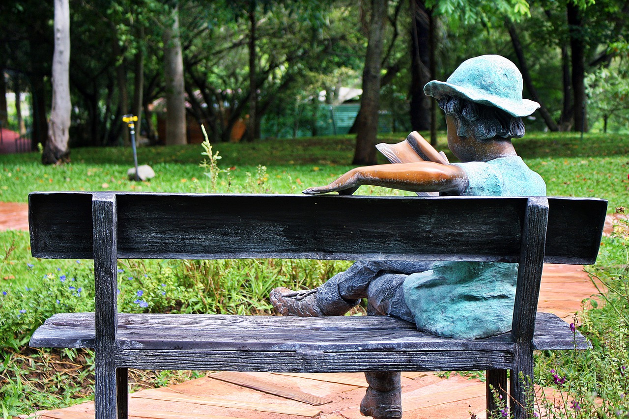 sculptures within the park  the resting place of all  statue of child reading a book outdoor free photo