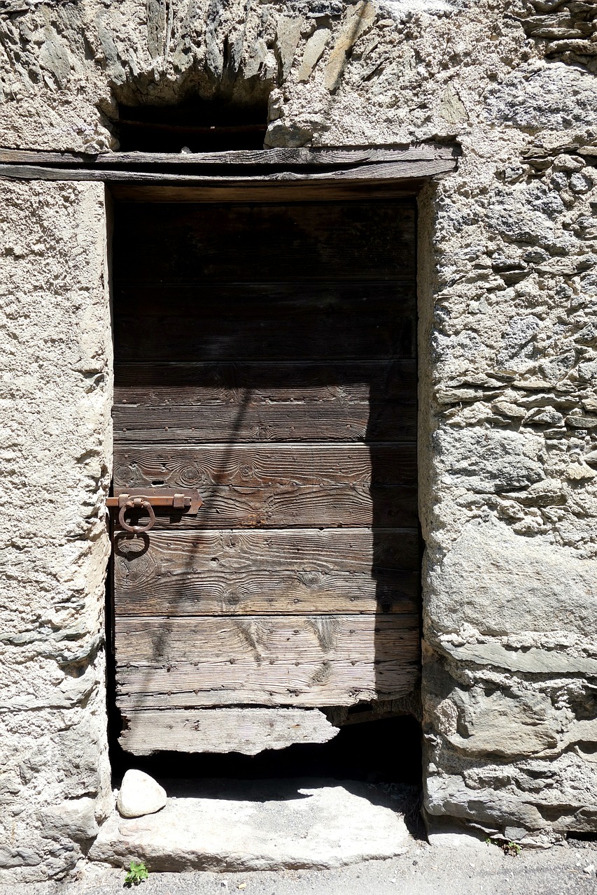Откройте дверь руин. Каменные окна в старых развалинах. Разрушенная стена с дверью. Старая разрушенная деревянная дверь. Потертая дверь в здание.