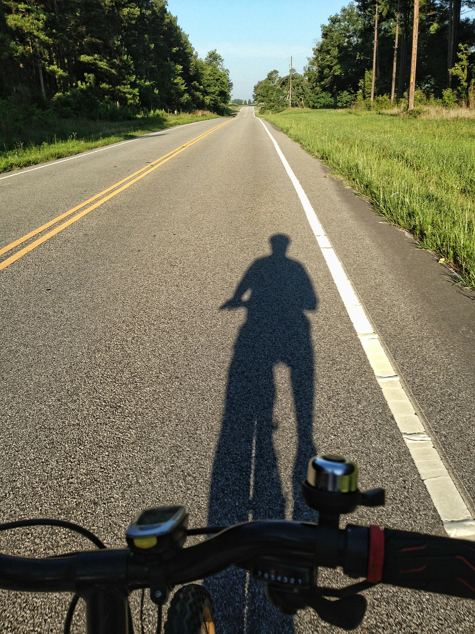 shadow of cyclist rural road cycling free photo