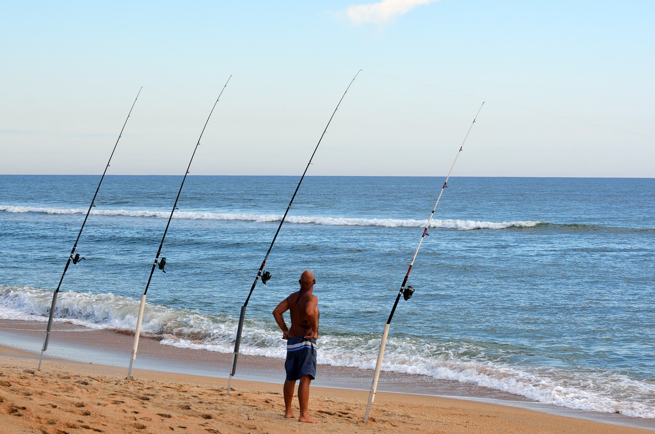 surf fisherman fishing poles sand spike free photo