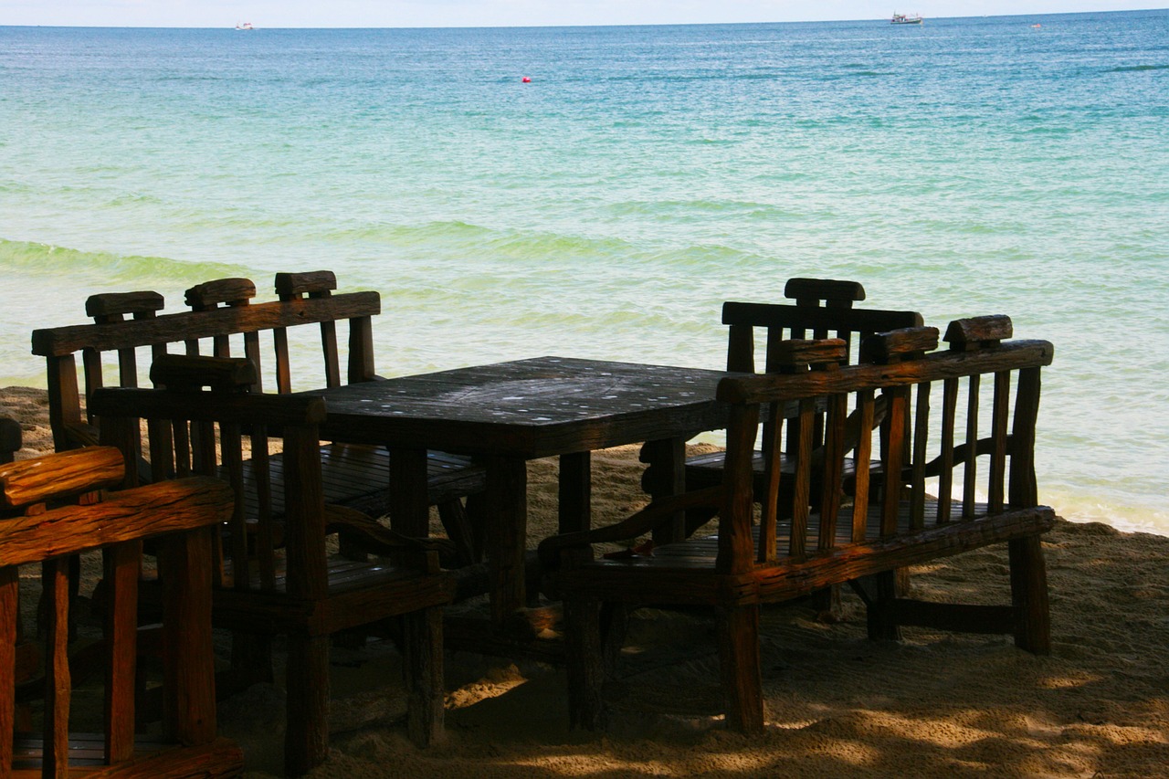 table and chairs ocean sand free photo
