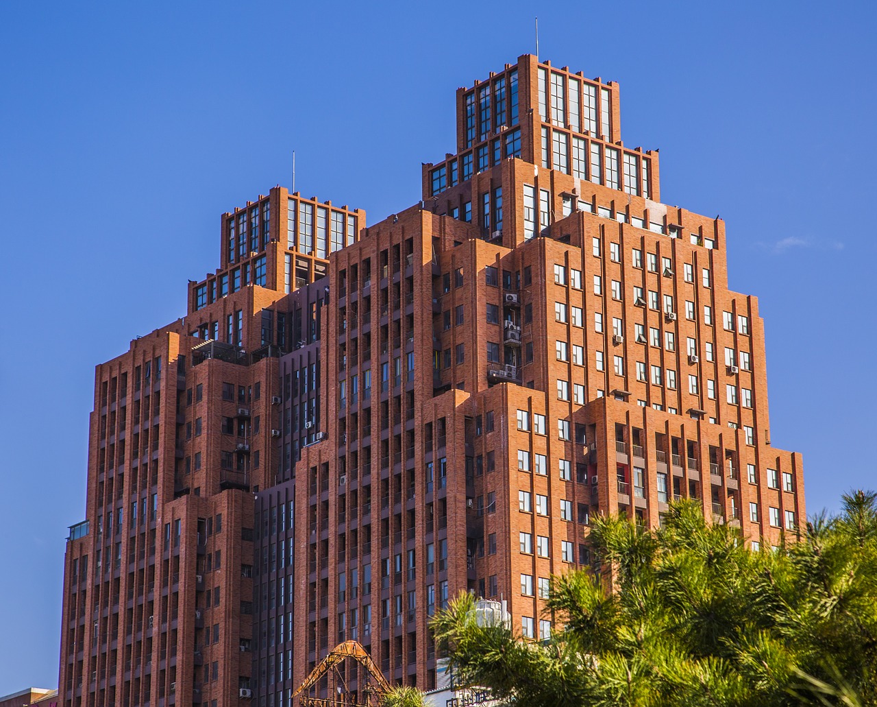 tall buildings a clear blue sky red house free photo