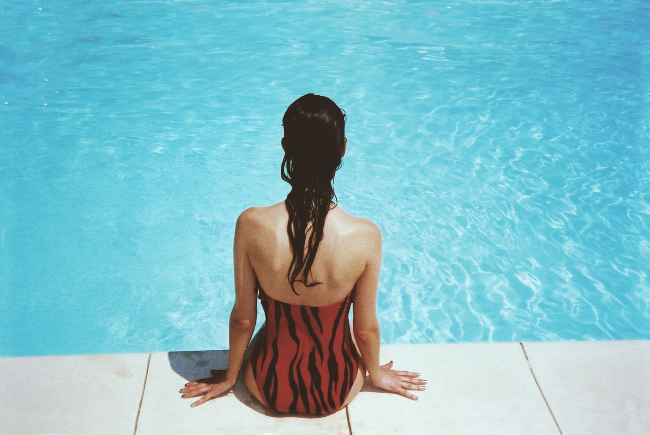 woman sitting poolside free photo
