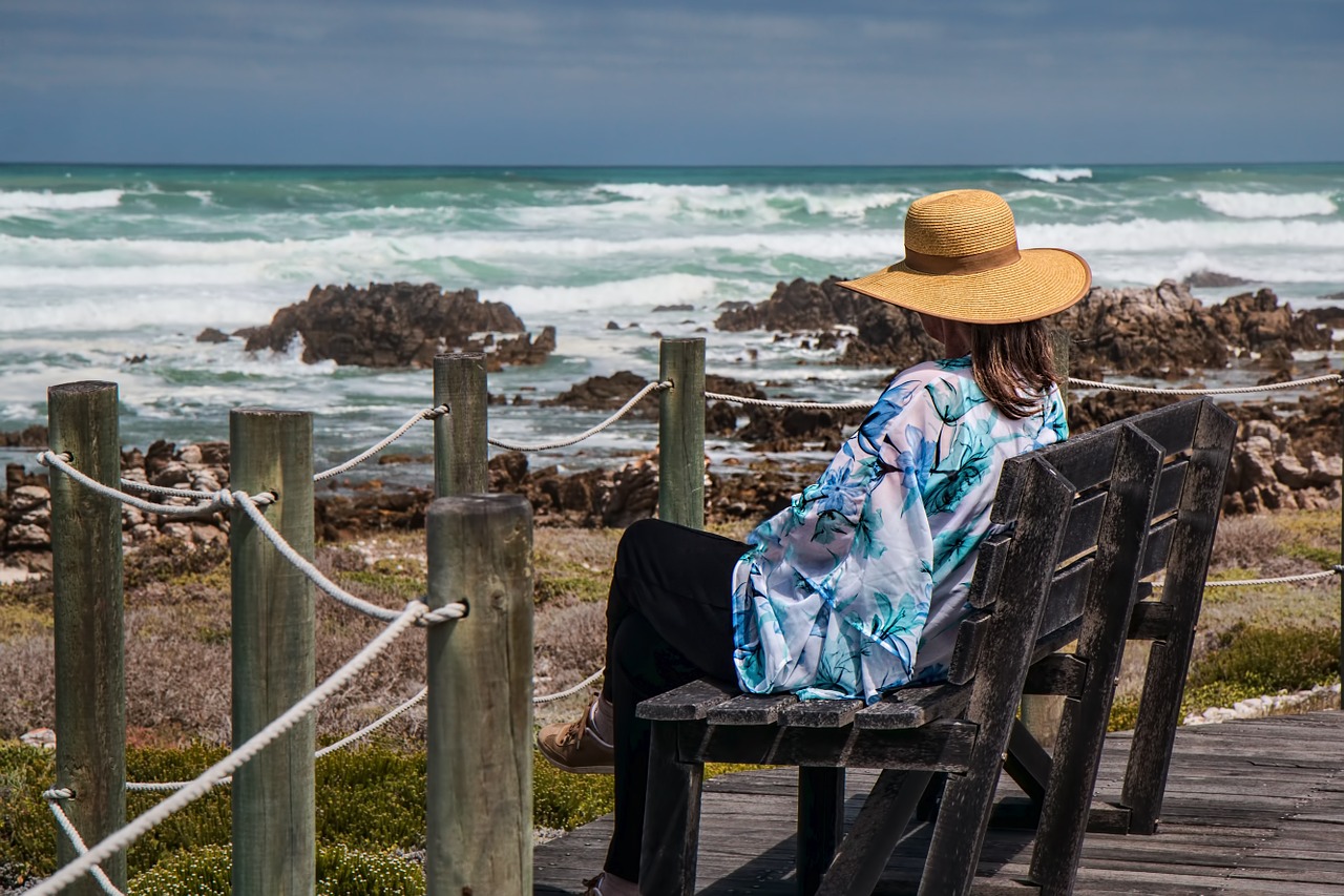 woman sitting seaside rocks free photo