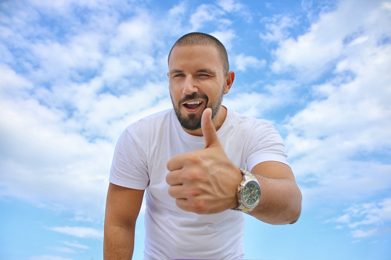 young man blue sky thumbs up free photo