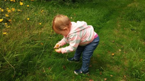 A Child Playing With Flowers