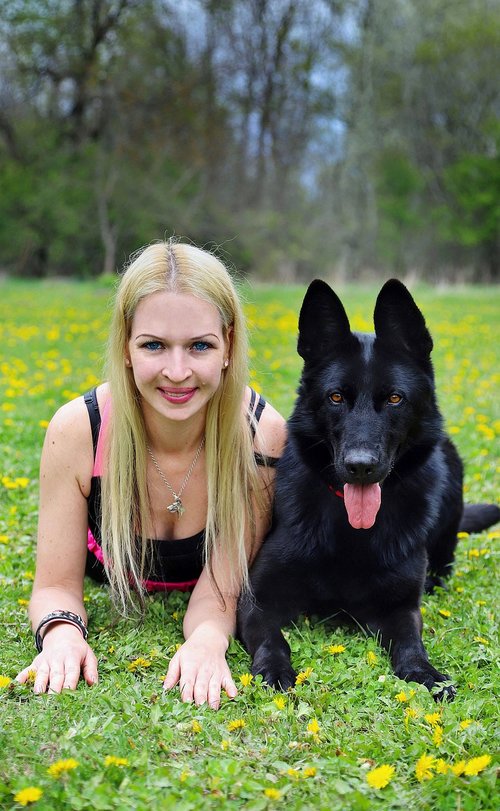 blonde woman  black  german shepherd
