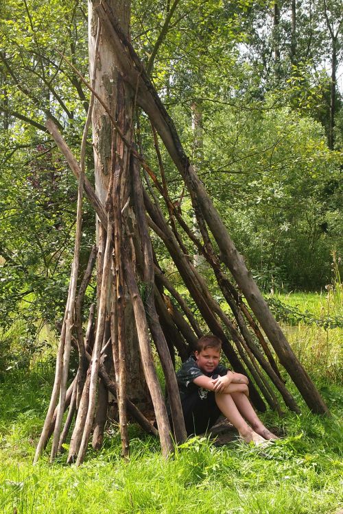 boy hut tree branches