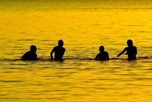 boys playing in lake  lake  dusk