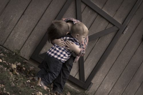 brothers hugging barn door