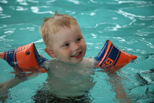 child swimming water wings