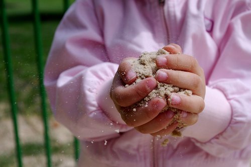child  hands  sand