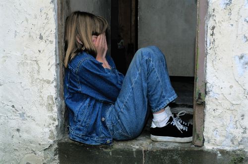 child sitting jeans in the door