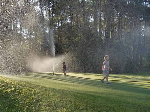 children sprinklers playing