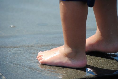 child's foot child playing in water shallow water