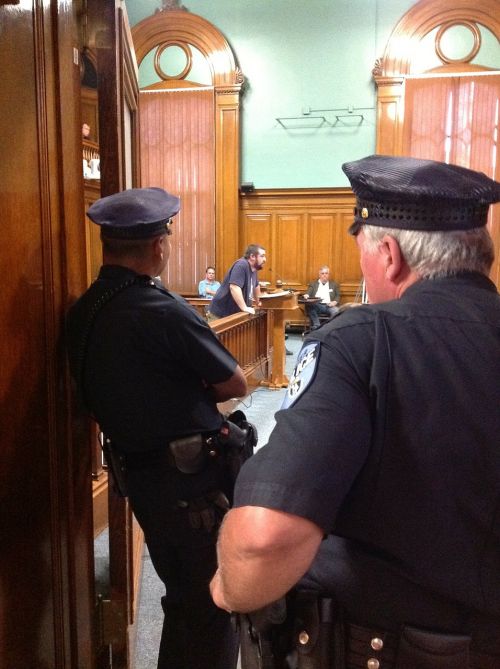 city council meeting police officers watching police officers
