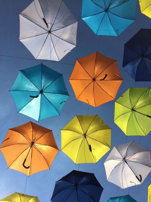 colorful umbrellas suspended in the air blue